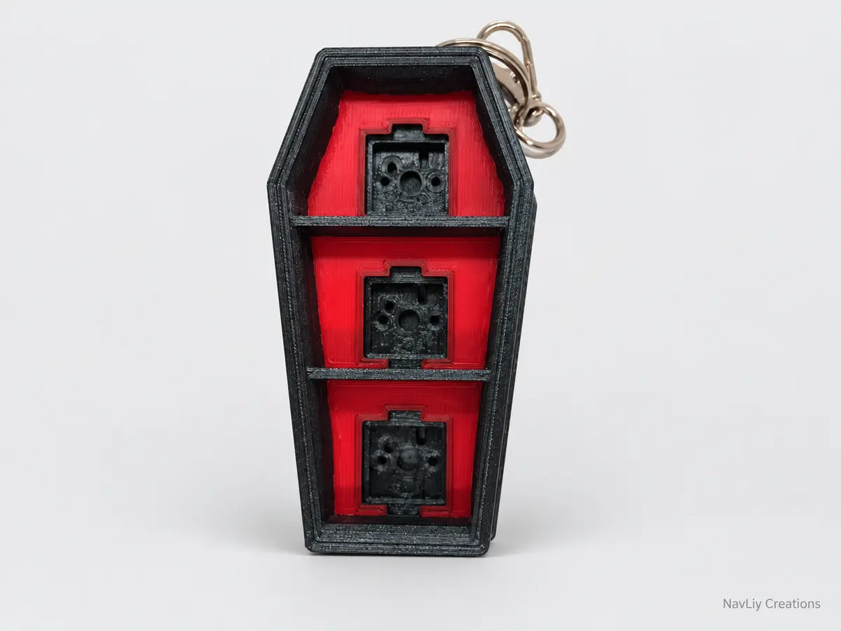 Black and red coffin-shaped three-button clicker keychain