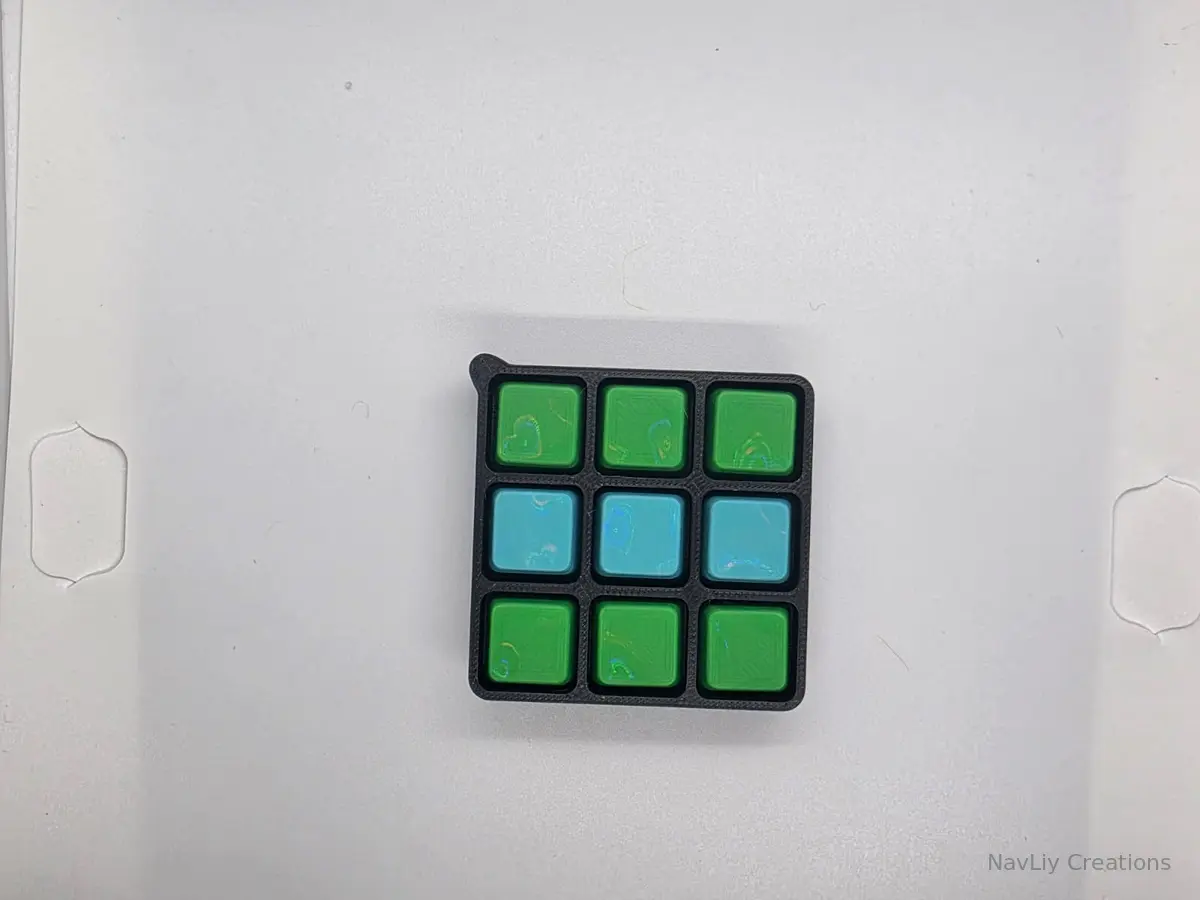 Black nine-key keyboard fidget with bright green and teal keycaps